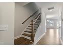 Staircase with wooden steps and railing, white walls, and hardwood floors in the entryway at 553 Eversden Dr, Zebulon, NC 27597
