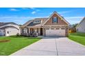 Charming single-Gathering home with a manicured lawn, stone accents, and a two-car garage at 258 Thistle Ct, Sanford, NC 27332