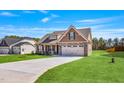 Charming single-Gathering home with a manicured lawn, stone accents, and a two-car garage at 258 Thistle Ct, Sanford, NC 27332