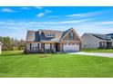 Charming single-Gathering home with a manicured lawn, stone accents, and a two-car garage at 258 Thistle Ct, Sanford, NC 27332