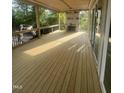 View of new covered deck with wood flooring, fireplace, and large sliding glass doors at 217 Dublin Rd, Raleigh, NC 27609