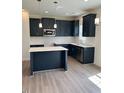 Modern kitchen features dark blue cabinetry, a center island, stainless steel appliances and wood floors at 253 Plains Dr # 264, Burlington, NC 27217