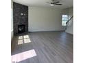 Spacious living room with wood floors, stacked stone fireplace, ceiling fan, and natural light at 253 Plains Dr # 264, Burlington, NC 27217