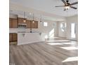 Open kitchen with island, hardwood floors, and modern appliances at 211 Wild Turkey Way, Lillington, NC 27546