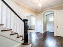Welcoming foyer boasts hardwood floors, arched doorways and detailed staircase with striking black and white banister at 2501 Kenmore Dr, Raleigh, NC 27608