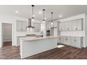 This spacious, modern kitchen boasts gray cabinetry, stainless appliances, granite countertops and hardwood floors at 3113 Petrea Ct # 38, Angier, NC 27501