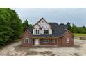 An elegant new two-story brick house featuring large windows and a covered front porch under construction at 6352 River Rd, Fuquay Varina, NC 27526