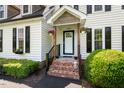 Inviting front porch with brick steps and decorative flower baskets at 135 Deep Creek, Rougemont, NC 27572