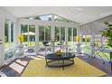 Bright sunroom featuring walls of windows and vaulted ceiling with beautiful backyard views at 135 Deep Creek, Rougemont, NC 27572