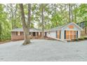 Inviting home showcases a brick exterior, white siding, black shutters, and a generous gravel driveway at 128 Dixie Dr, Chapel Hill, NC 27514