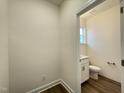 Powder room showcases a window providing natural light, paired with modern fixtures and white cabinets at 490 Traditions Grande Blvd # 27, Wake Forest, NC 27587