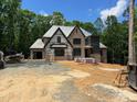 Front view of a brick home under construction with building wrap and stacked bricks at 67 Ridgeline Ct # 7, Pittsboro, NC 27312