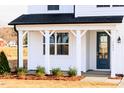 Close up of the covered front porch and blue front door of this new construction home at 7417 Prato Ct, Wendell, NC 27591