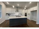 Modern kitchen featuring a central island, stainless steel appliances, and sleek white cabinets at 321 Murray Grey Ln, Wake Forest, NC 27587