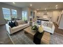 Open-concept living room featuring hardwood floors, plush sofas, and large windows for ample natural light at 321 Murray Grey Ln, Wake Forest, NC 27587