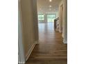 Hallway view leading to a bright living area with wood-look flooring and staircase on the right at 104 Gin Branch Rd, Wendell, NC 27591