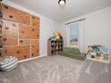 Playroom with climbing wall, plush carpet, window, and storage shelves at 137 Shadowdale Ln, Rolesville, NC 27571