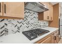 Modern kitchen features gas cooktop and herringbone backsplash at 1429 Patchings Ln, Knightdale, NC 27545