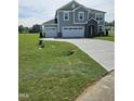 Charming two-story home with a three-car garage, stone details, and a freshly sodded lawn at 7420 Prato Ct, Wendell, NC 27591