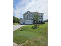New two-story home featuring a three-car garage, stone accents, and a meticulously landscaped front yard at 7420 Prato Ct, Wendell, NC 27591