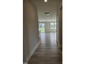 Hallway view with modern flooring leading to a bright, open living space with a sliding glass door at 7420 Prato Ct, Wendell, NC 27591