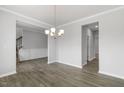 Bright dining room with elegant chandelier, wainscoting, and modern wood flooring at 1301 Jasmine View Way, Knightdale, NC 27545