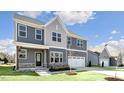 Inviting home with gray siding, a cozy front porch, and an attached two-car garage at 1301 Jasmine View Way, Knightdale, NC 27545