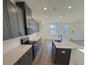 Contemporary kitchen showcasing gray cabinetry, light countertops, and stainless steel appliances at 29 Longdale Dr, Graham, NC 27253