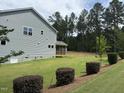 Side view of a two-story home with a backyard, screen porch and manicured landscaping at 135 Green Haven Blvd # 1, Youngsville, NC 27596