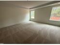 Spacious bedroom with neutral carpet, tray ceiling, and large windows offering natural light at 135 Green Haven Blvd # 1, Youngsville, NC 27596