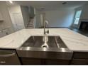 Kitchen island with sink, stainless steel appliances, with view of stairs and living room at 135 Green Haven Blvd # 1, Youngsville, NC 27596