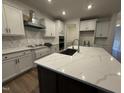 Bright kitchen features white cabinets, stone countertops, an island, and stainless steel appliances at 135 Green Haven Blvd # 1, Youngsville, NC 27596
