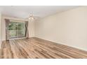 An empty, bright living room showcases wood-style flooring and a sliding glass door to a balcony at 3000 Trailwood Pines Ln # 204, Raleigh, NC 27603