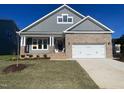 New two-story home with gray siding, brick accents, a two-car garage, and well-maintained lawn at 1504 Maelyn Way, Fuquay Varina, NC 27526