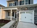 Front view of a two-story house with a white garage door and stone accents at 215 Britt St, Smithfield, NC 27577