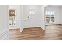Bright foyer boasts wood-look floors, wainscoting, and a front door with sidelight windows at 490 Oak Park Blvd, Youngsville, NC 27596