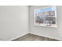 Bright bedroom with a view of the neighborhood, featuring hardwood floors and light gray walls at 1304 Jasmine View Way, Knightdale, NC 27545