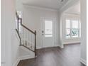 Bright foyer featuring hardwood floors, staircase, and front door with sidelight windows at 524 Lemon Daisy Ln, Knightdale, NC 27545