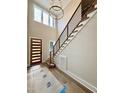 Entryway featuring a wood front door, high ceilings, modern light fixture, and stairway at 205 Red Cardinal Ct, Youngsville, NC 27596