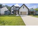 New two-story construction home with modern farmhouse design, detailed trim, and a lush manicured lawn at 205 Red Cardinal Ct, Youngsville, NC 27596