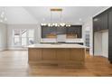 A gourmet kitchen with a large island, modern cabinetry, designer lighting, and stainless steel appliances at 205 Red Cardinal Ct, Youngsville, NC 27596