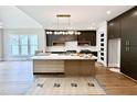Spacious kitchen featuring stainless appliances, an island with a marble countertop, and dark cabinetry at 205 Red Cardinal Ct, Youngsville, NC 27596