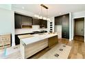 Bright kitchen with stainless appliances, light wood island, dark cabinets, and modern lighting at 205 Red Cardinal Ct, Youngsville, NC 27596
