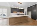 A modern kitchen featuring a large island, stainless steel appliances, and designer lighting at 205 Red Cardinal Ct, Youngsville, NC 27596
