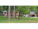 Brick home with mature trees, a spacious yard, and work vehicles at 7610 Buckhorn Rd, Hillsborough, NC 27278