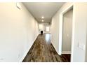 Hallway view with wood-look flooring leading to an open living space with a fireplace and plenty of natural light at 55 Capeside Ct, Lillington, NC 27546