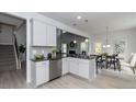 Bright, modern kitchen featuring white cabinets, gray backsplash, stainless steel appliances, and an open layout at 19 Streamline Ct, Lillington, NC 27546