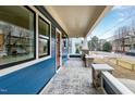 Inviting covered front porch with stone accents, stamped concrete flooring, and blue siding at 417 E Moore St, Apex, NC 27502