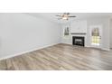 Living room with fireplace, wood-look floors and French doors at 49 Lupin Dr, Smithfield, NC 27577