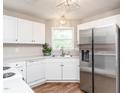 Bright kitchen featuring white cabinets, stainless steel appliances, and wood flooring at 2227 Delaney Dr # 313, Burlington, NC 27215